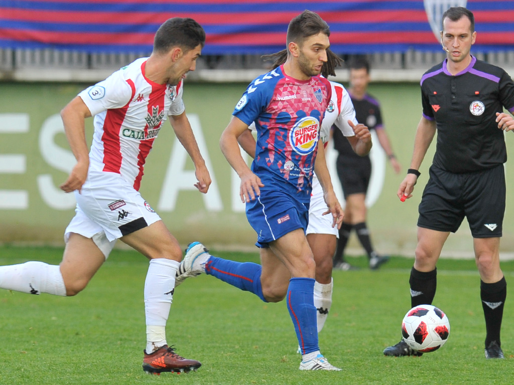 Alex Conde, que apunta a la titularidad, corre con el balón perseguido por un rival del Zamora. / KAMARERO