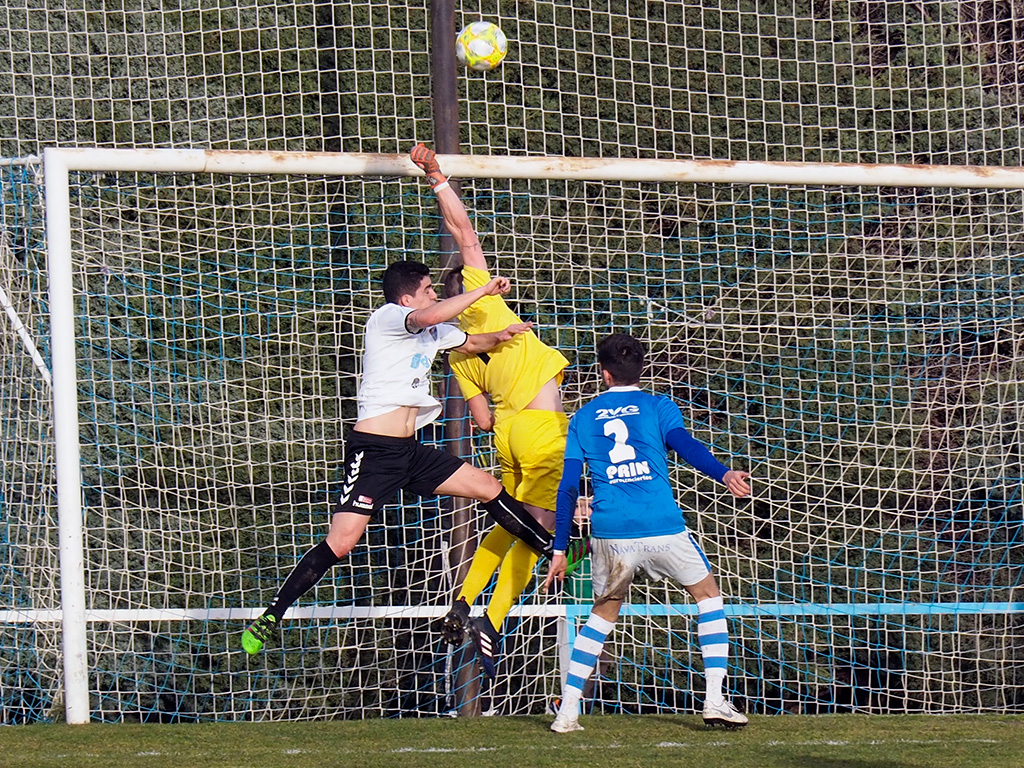 Loren consigue despejar con el puño en un balón colgado al área del Club Deportivo La Granja al que intentaba llegar el delantero de la Segoviana, Ivi./ KAMARERO