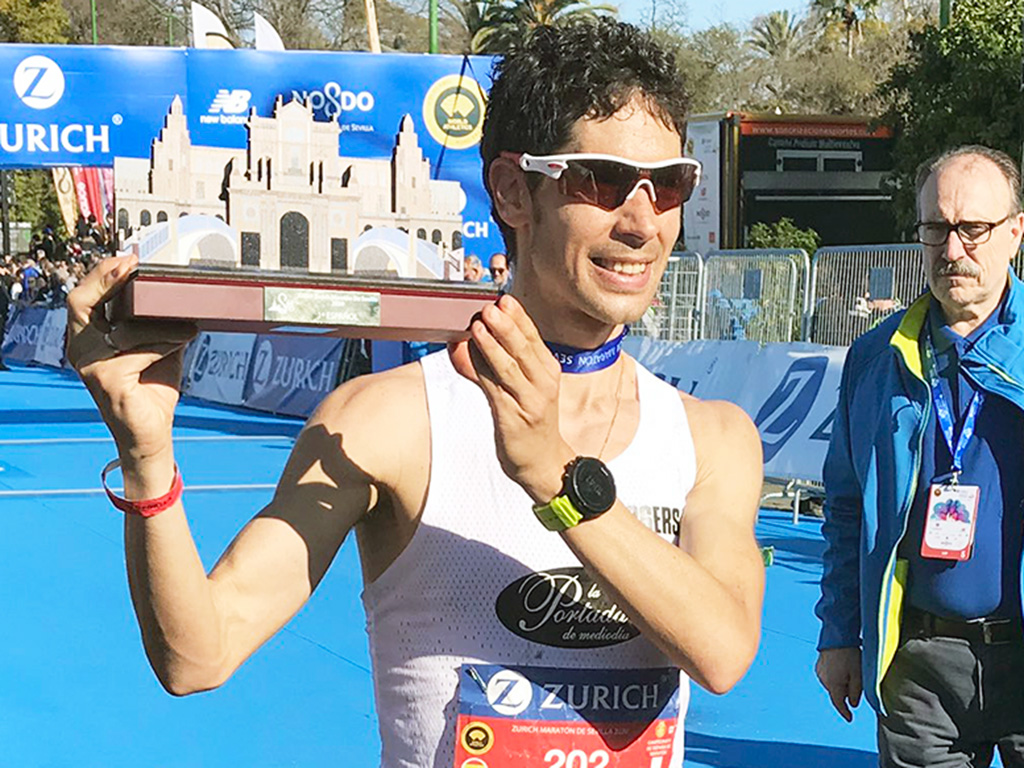 Guerra, con uno de los trofeos recibidos tras la maratón de Sevilla. / EFE