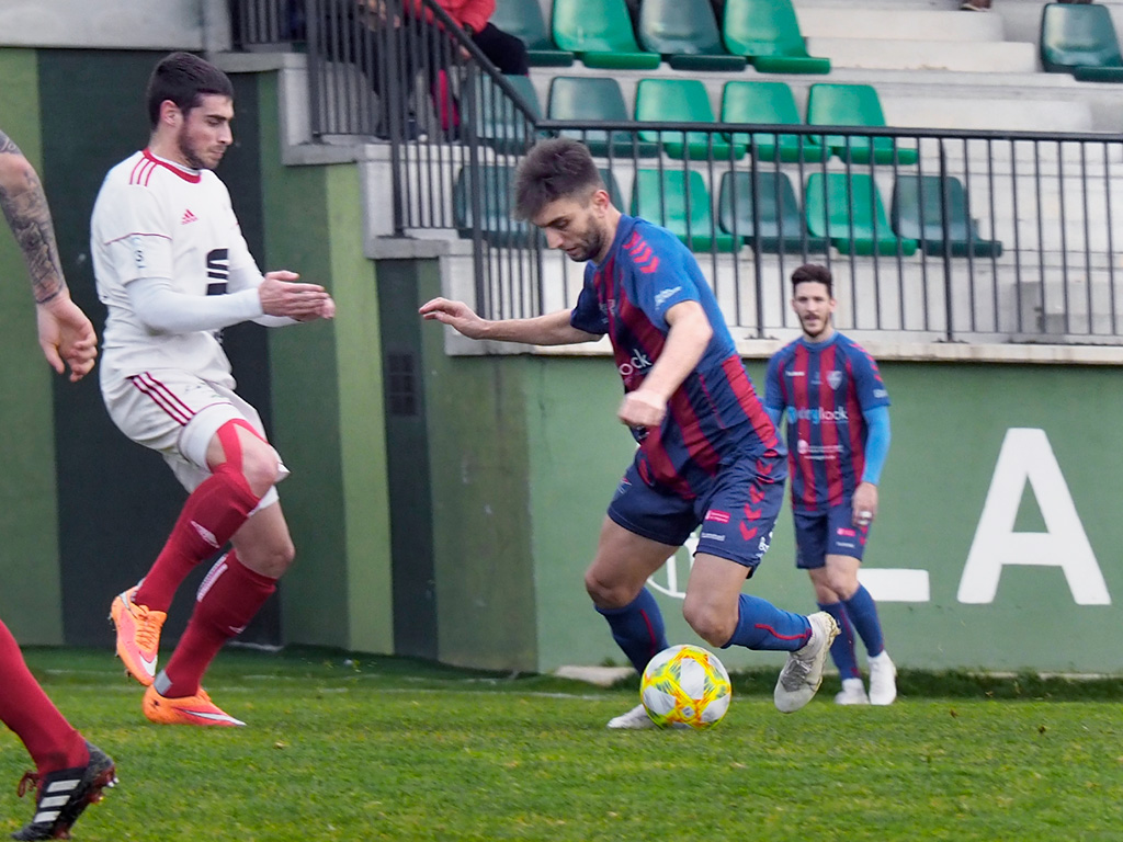 Álex Conde intenta regatear a un contrario durante el encuentro ante el Bupolsa. / NEREA LLORENTE