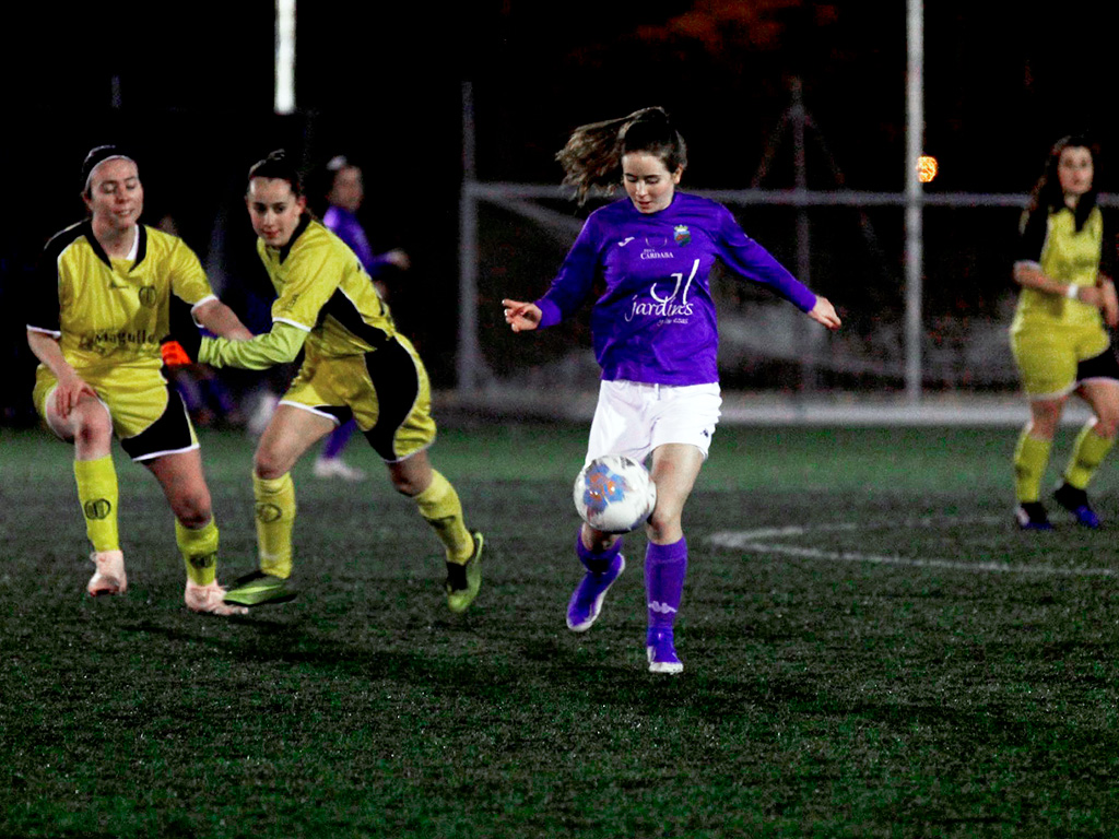 La jugadora del Monteresma controla el balón en la medular tras superar a dos componentes del Quintanar./ NEREA LLORENTE