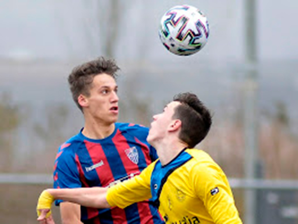 Un balón dividido en el partido entre Segoviana y Diocesanos./ JUAN MARTÍN-GIMNÁSTICA SEGOVIANA
