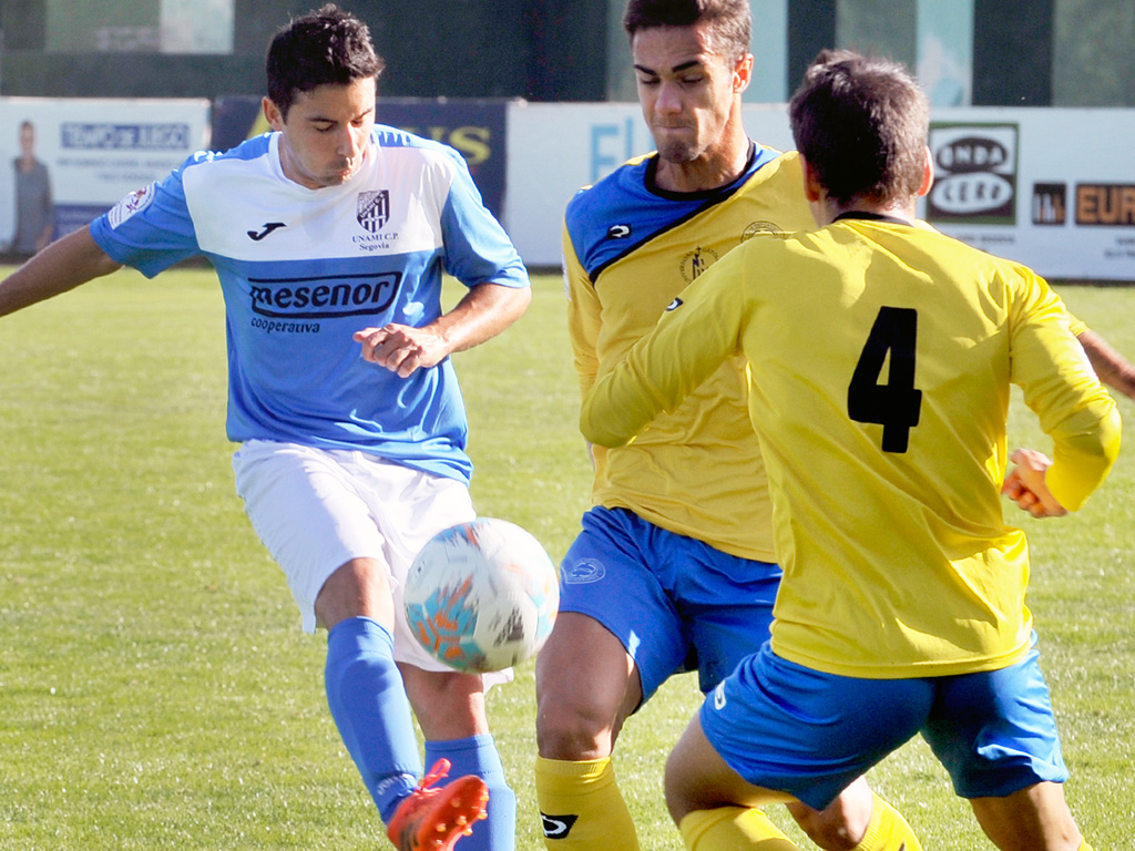 El centrocampista del Unami CP Quino ejecuta un pase ante la presión de los rivales del Diocesanos. / KAMARERO