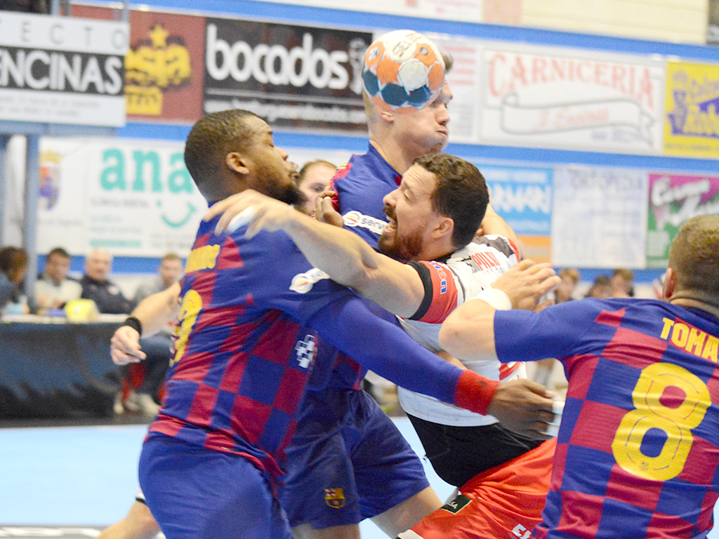 El jugador del Balonmano Nava Andrés Alonso intenta traspasar la defensa del Barcelona. / A. MARUGÁN