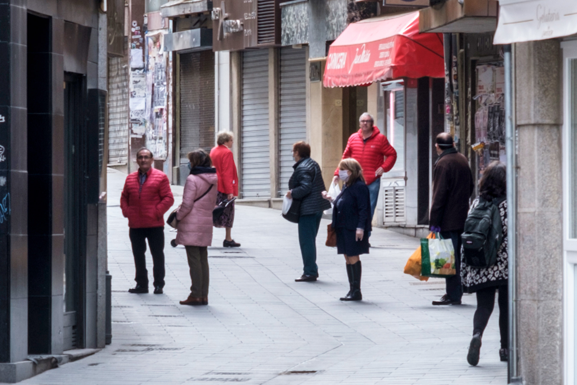 Algunos segovianos guardan cola a las puertas de un comercio respetando la distancia de seguridad.