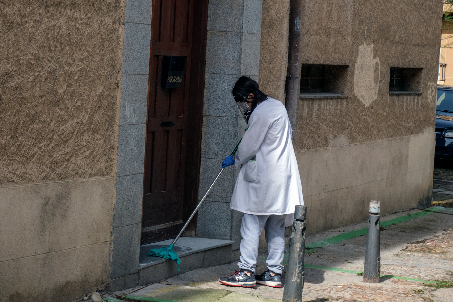 Una persona desinfecta la entrada de una casa para evitar posibles contagios por coronavirus.