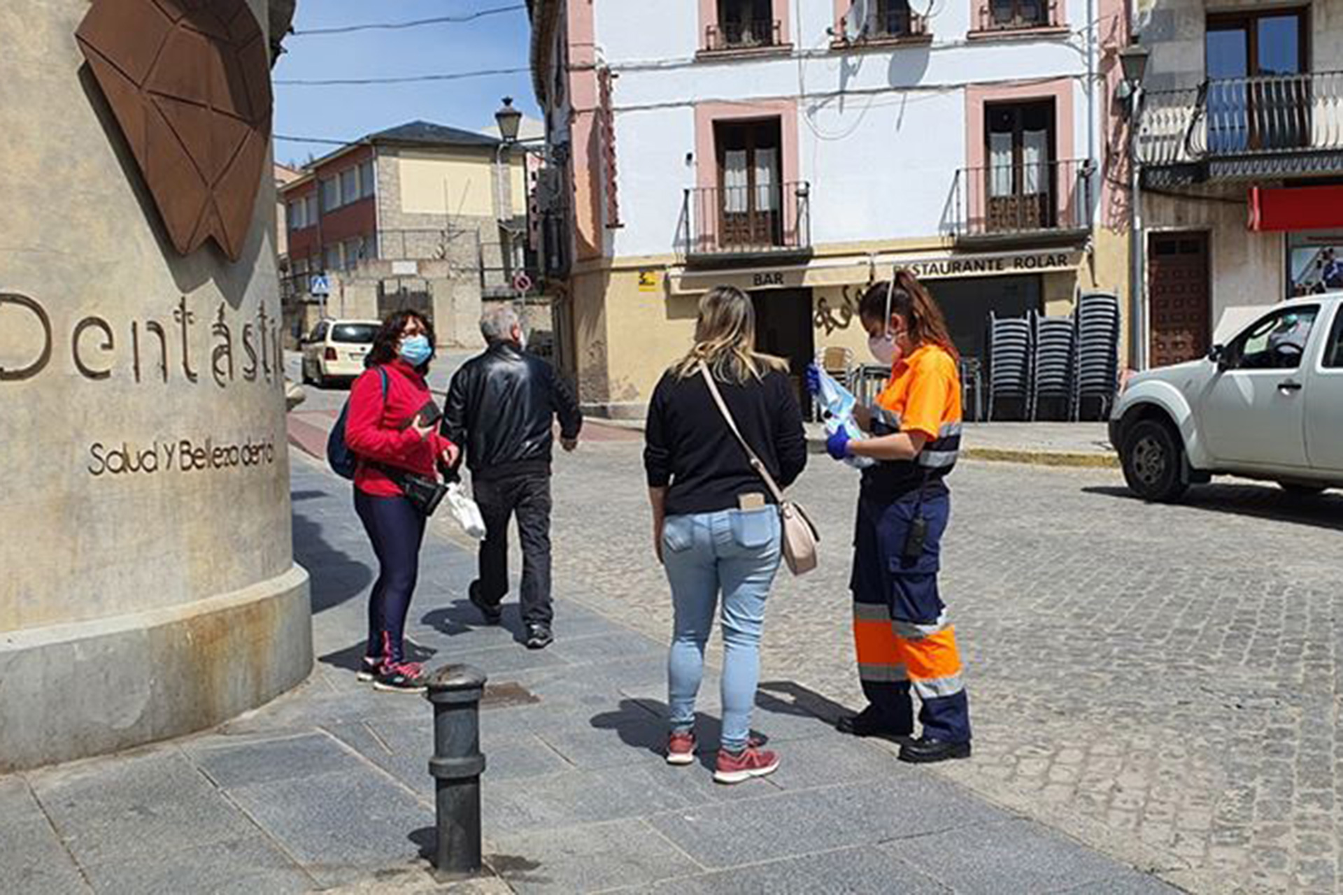 Una voluntaria reparte mascarillas en El Espinar. /E.A.