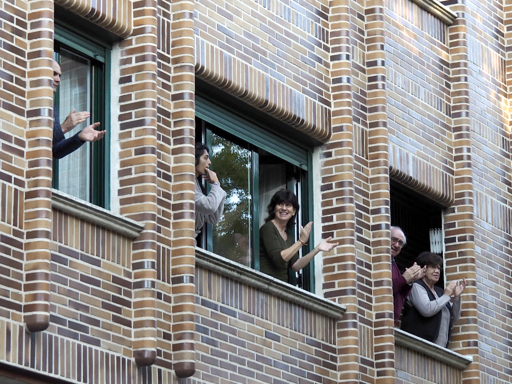 Personas aplaudiendo desde sus ventanas agradeciendo el trabajo de los sanitarios durante la pandemia./ NEREA LLORENTE