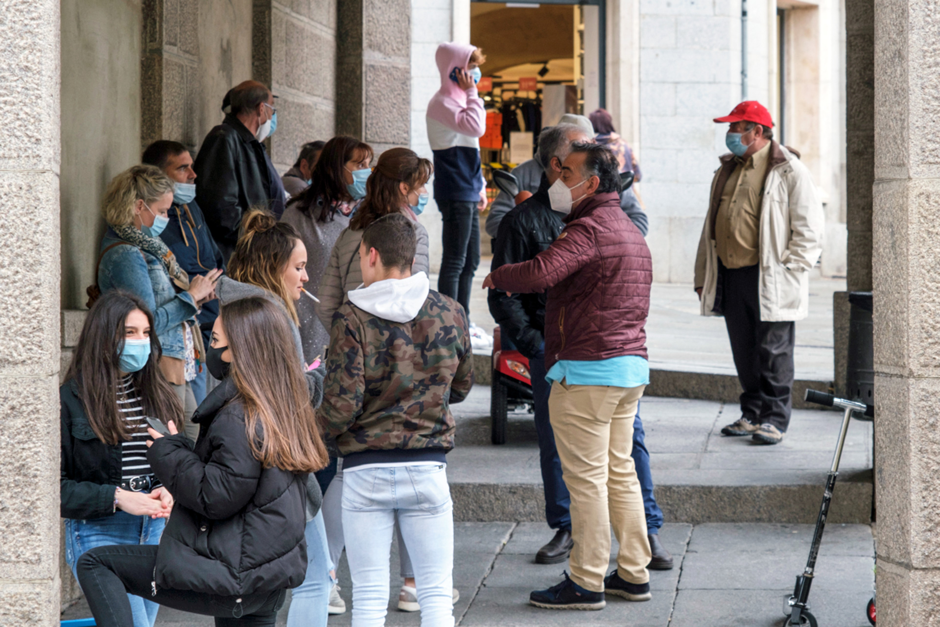 Varios grupos de personas descansan en los soportales de la Plaza del Azoguejo.