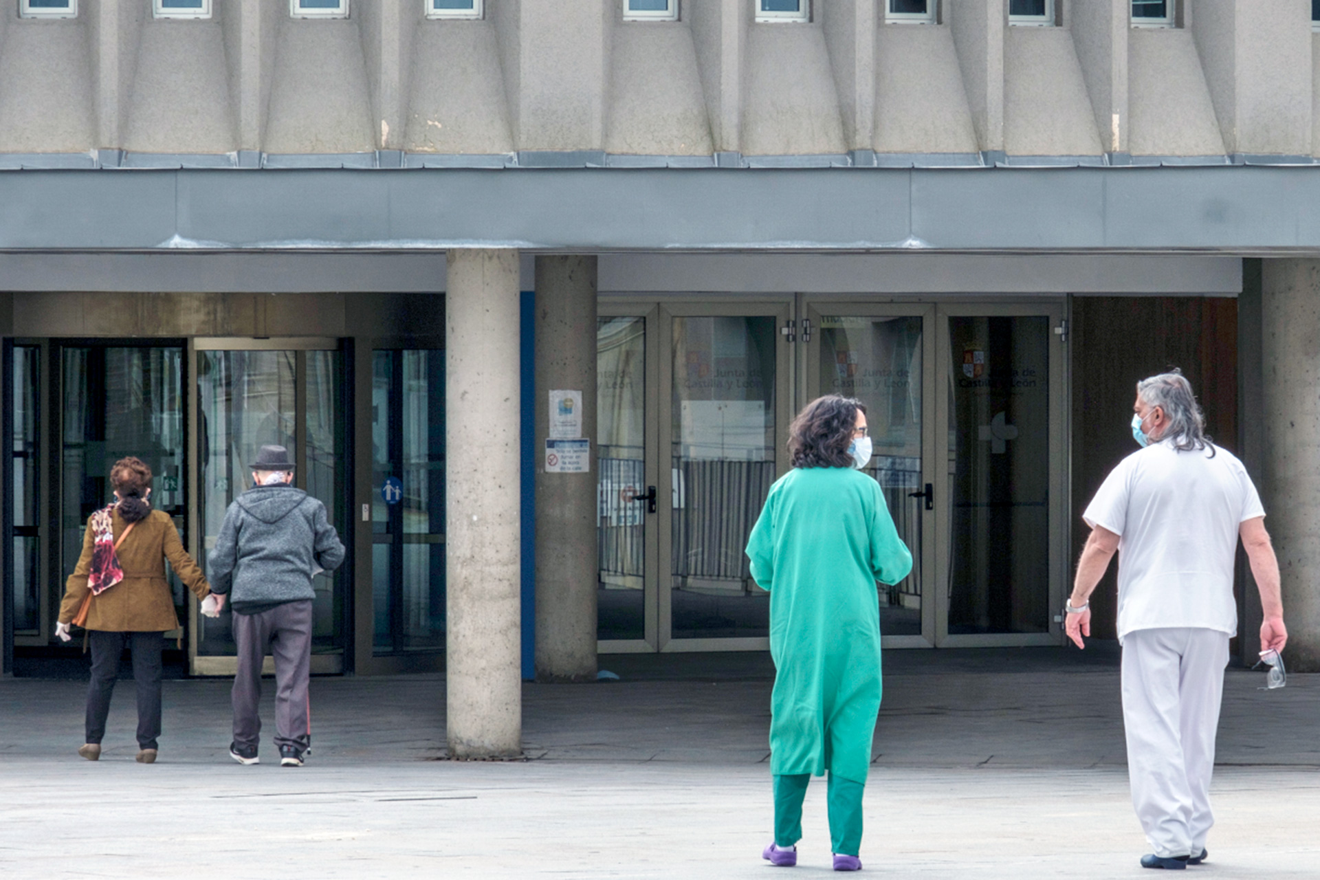 Ciudadanos y personal sanitario se disponen a entrar en el Hospital General.