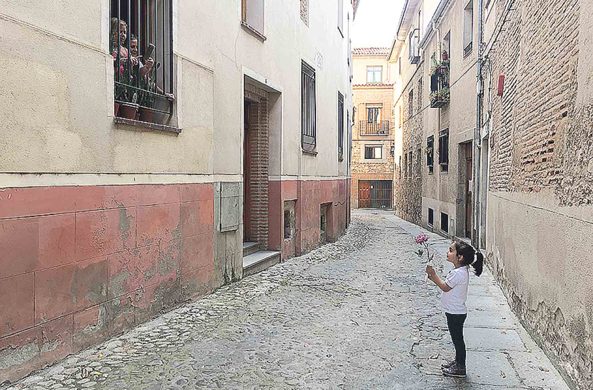 Una niña saluda a sus familiares durante el confinamiento en Segovia. / Roberto Arribas