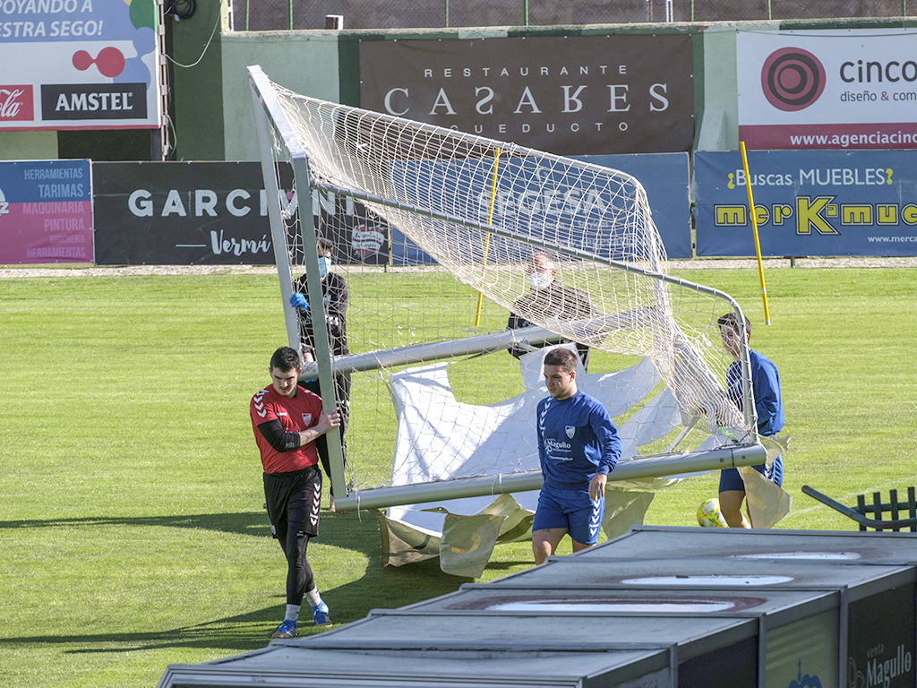 Varios jugadores de la Segoviana trasladan una portería para llevar a cabo uno de los ejercicios de entrenamiento. / KAMARERO