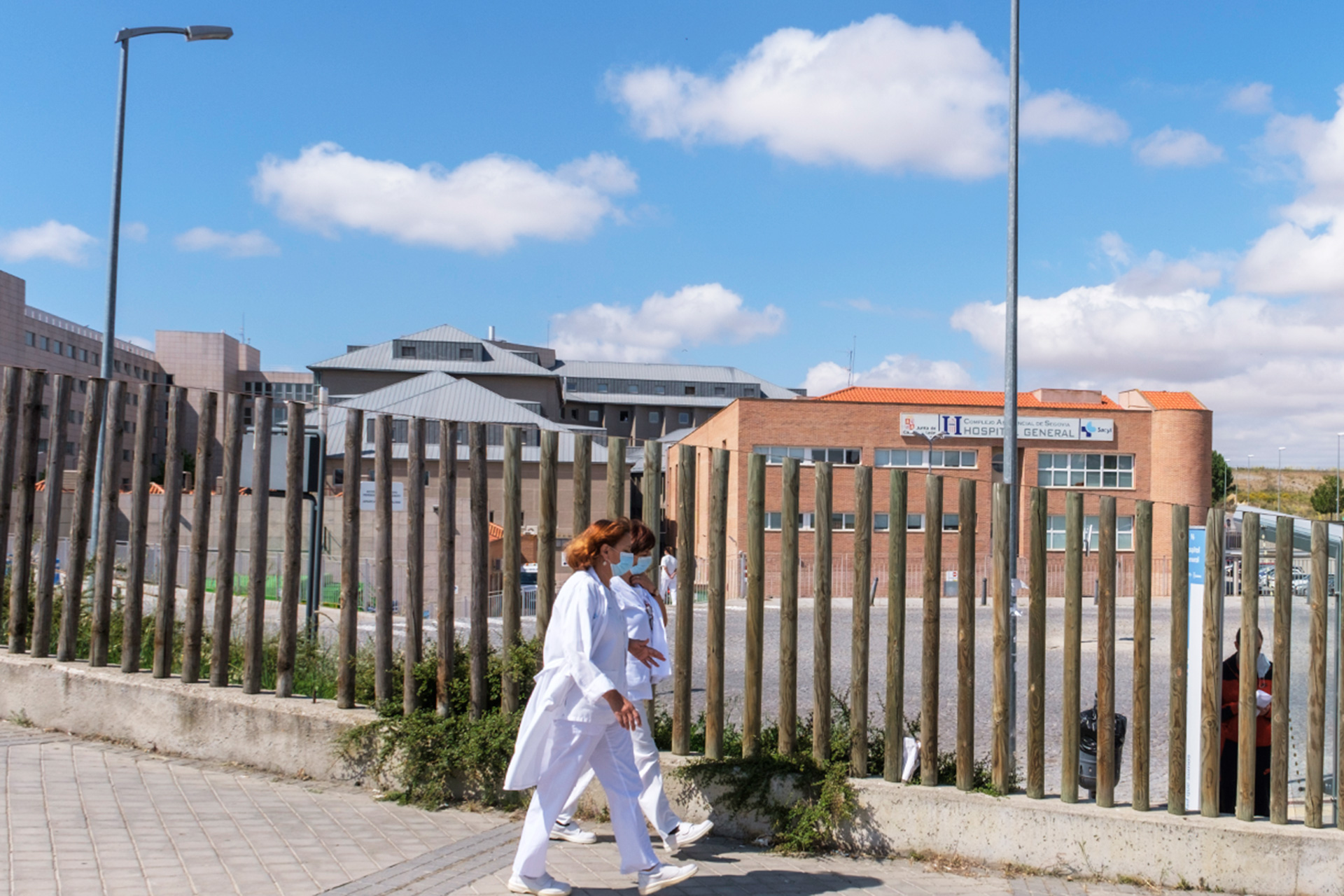 Dos miembros del personal sanitario pasean por las inmediaciones del Hospital General de Segovia. / KAMARERO