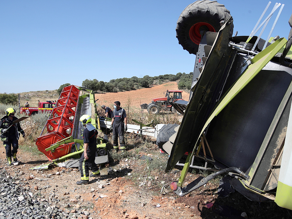 Bomberos atienden el accidente tras la colisión de ambos medios.  / EFE