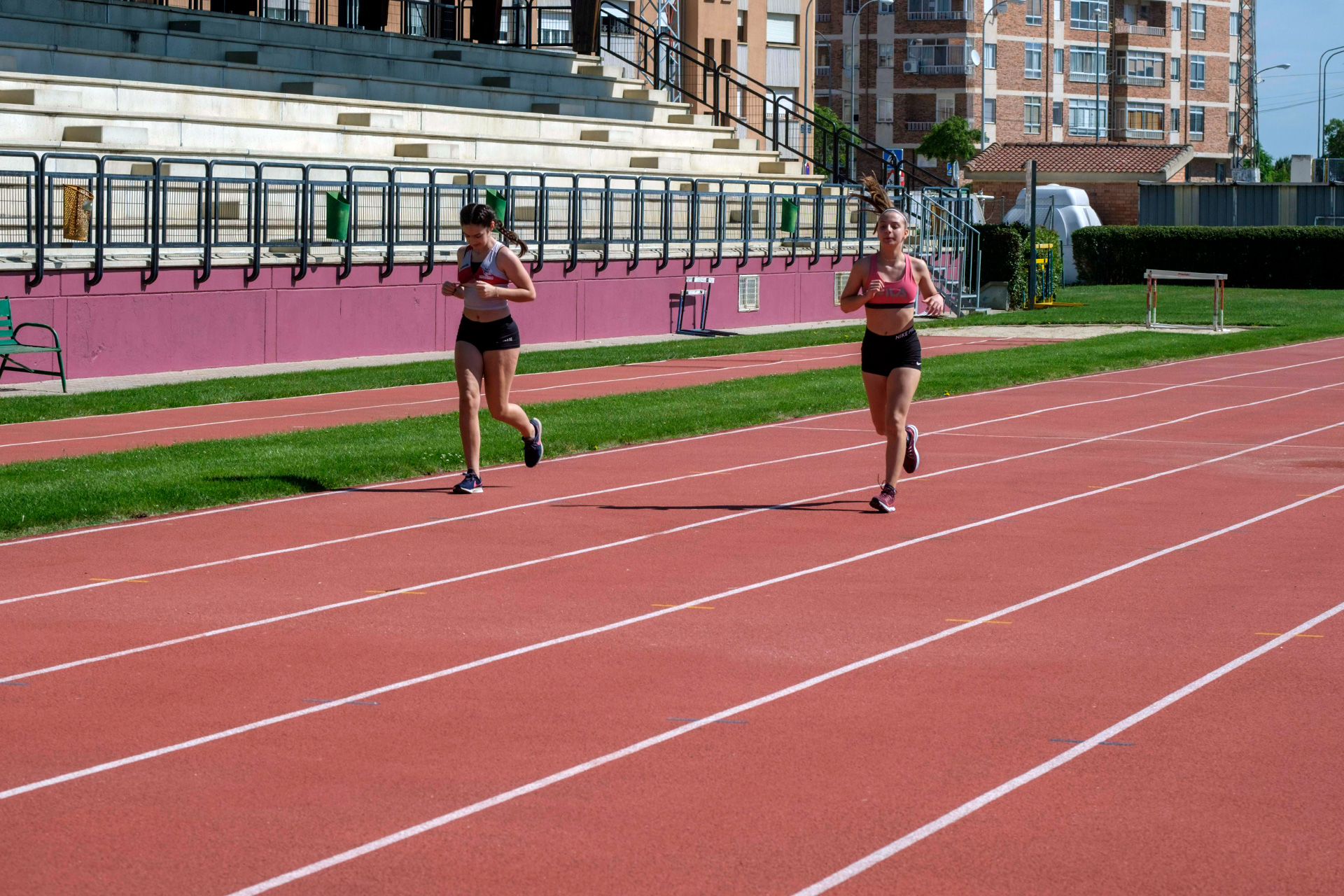 Dos atletas entrenan en las pistas de atletismo Antonio Prieto, del complejo polideportivo de La Albuera, este verano. / KAMARERO
