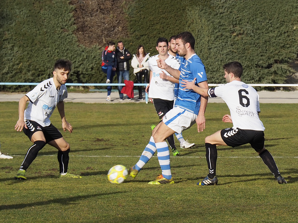 Víctor Velasco, del CD La Granja, es presionado por Álex Conde y Manu, de la Gimnástica Segoviana. / KAMARERO