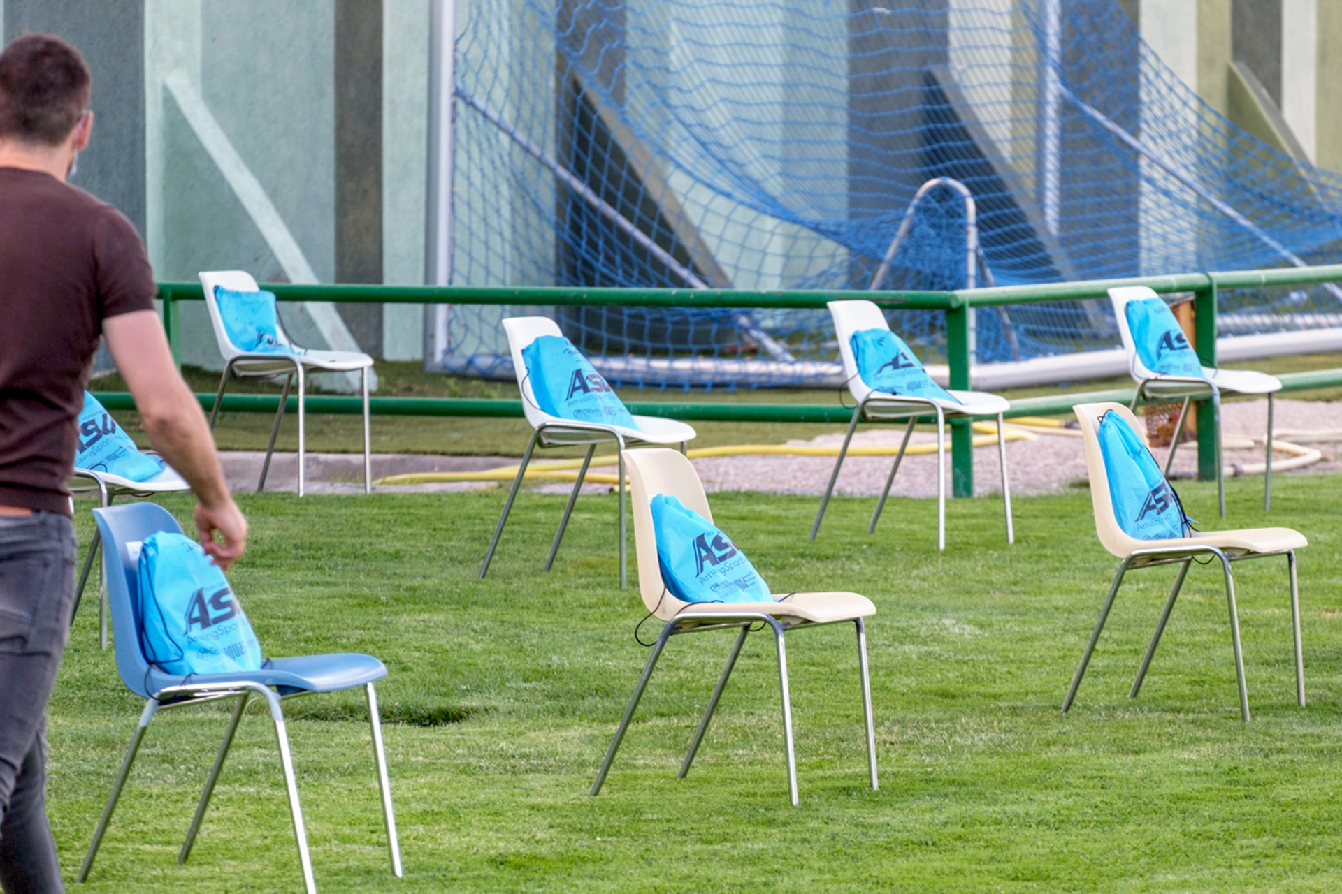 Sillas con kits individualizados para los futbolistas de la Gimnástica Segoviana en uno de los entrenamientos del equipo azulgrana./ KAMARERO