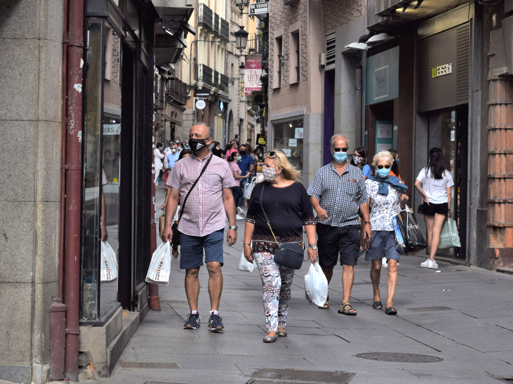 Varias personas pasean con mascarillas por la Calle Real de Segovia.