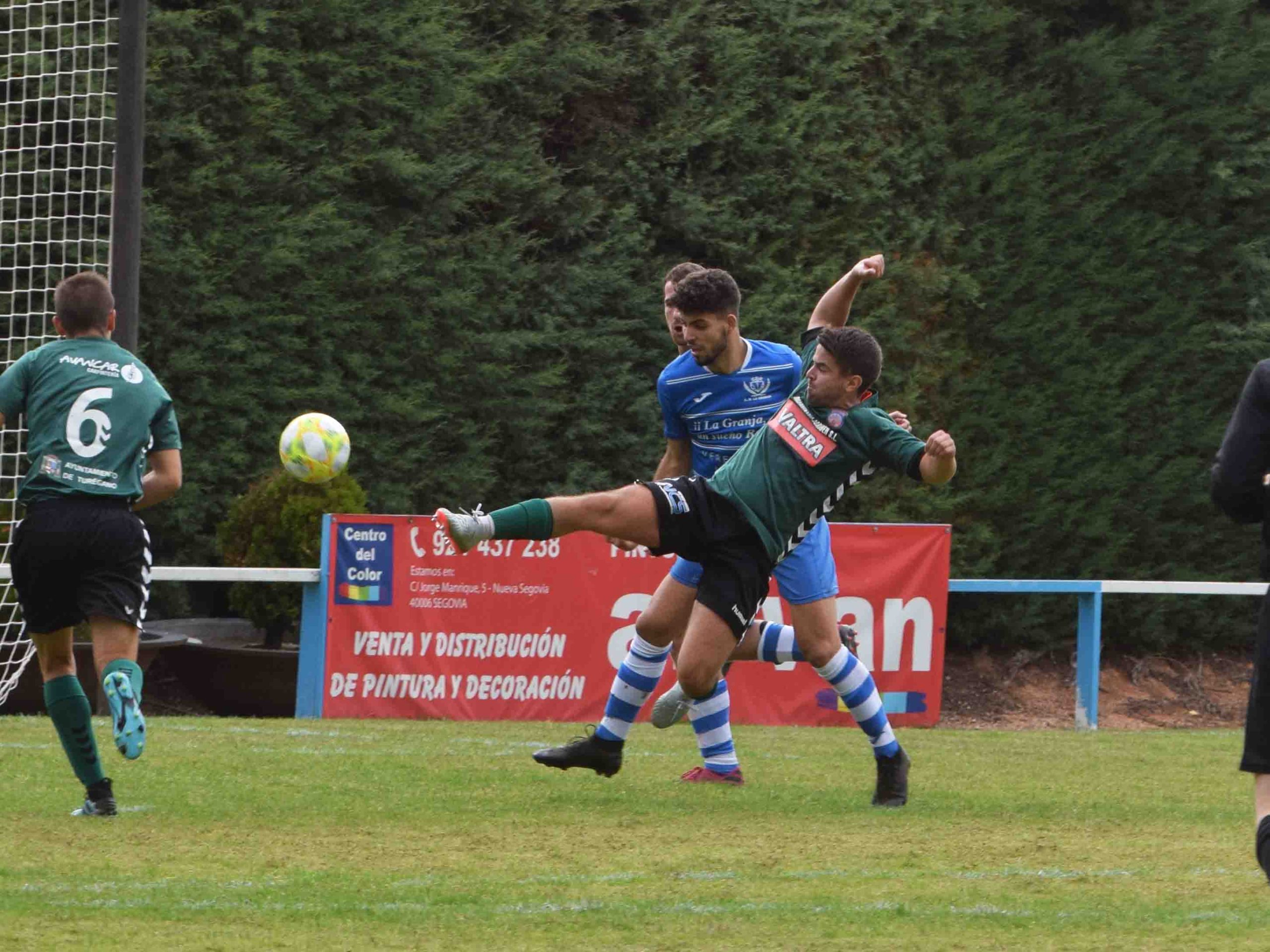 Dani, del Turégano, estira la pierna para intentar llegar al balón ante la presión del CD La Granja. / ROCÍO PARDOS