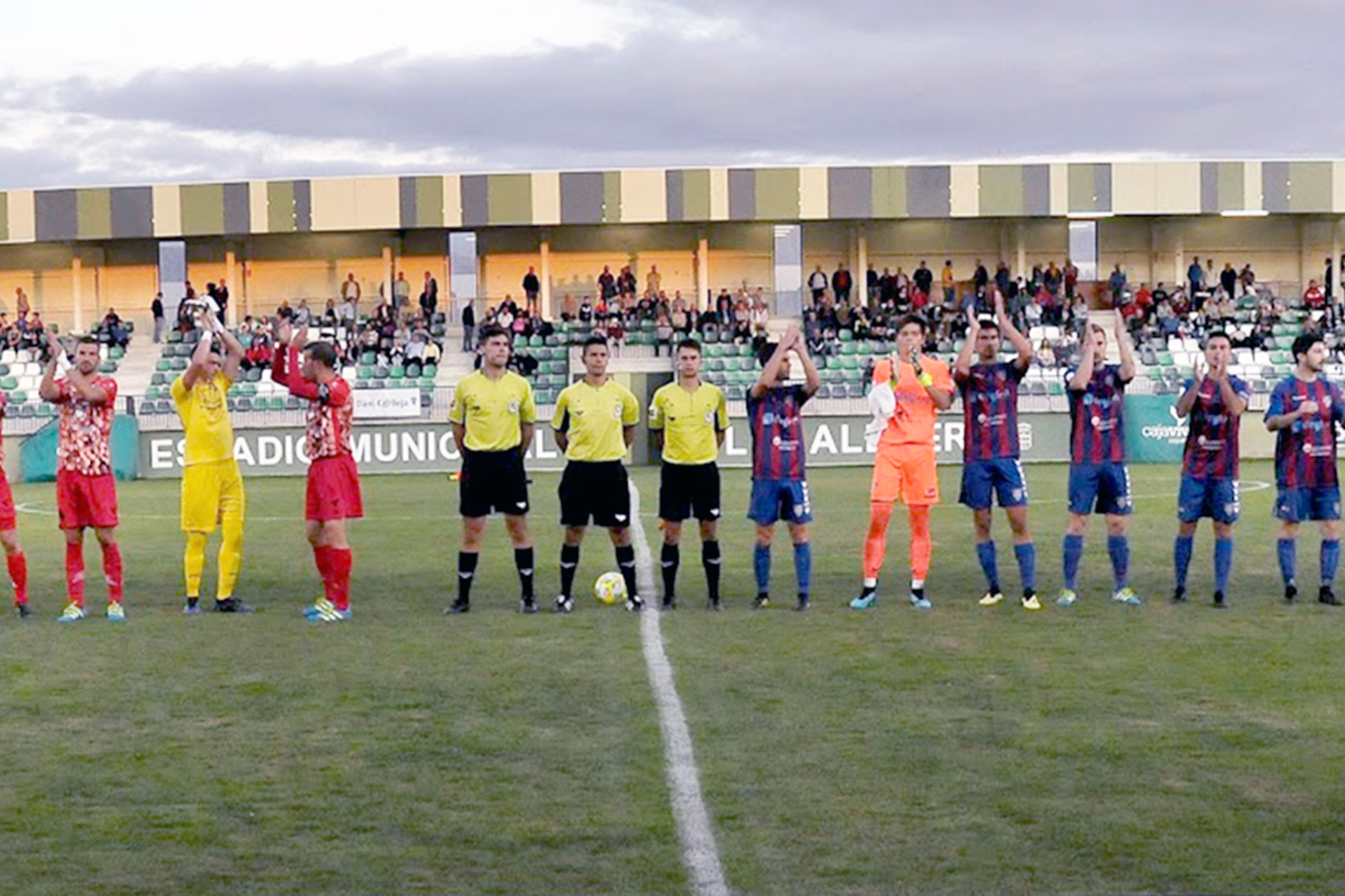 Los futbolistas de Gimnástica Segoviana y CD La Granja saludan a los aficionados en los prolegómenos de un partido./ J.M./G.SEGOVIANA