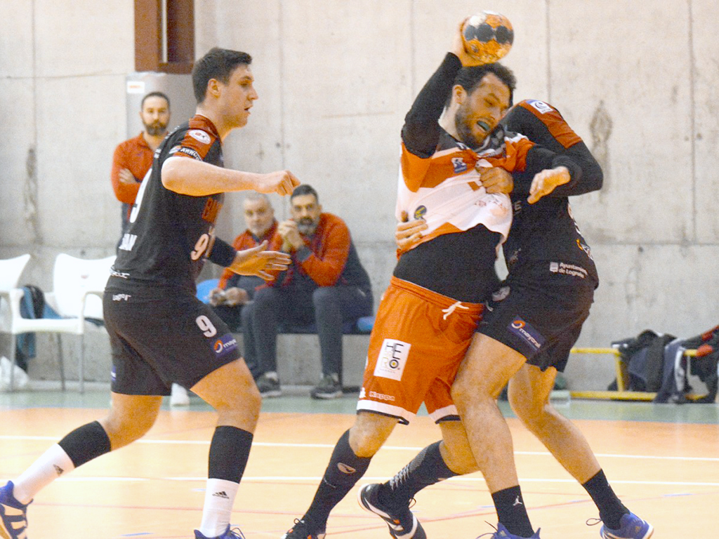 Darío Ajo, frenado por un jugador del Ciudad de Logroño en el encuentro que ambos conjuntos disputaron en el mes de febrero./ AMADOR MARUGÁN