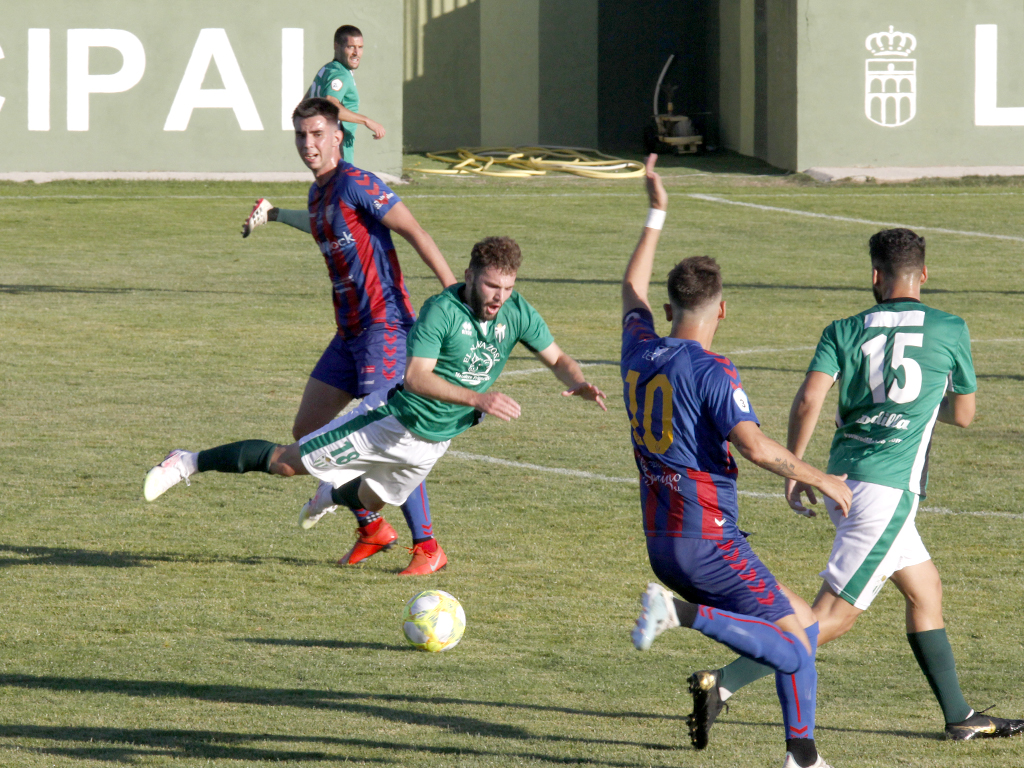 El jugador del Guijuelo cae ante la entrada del centrampista de la Segoviana, Pablo. / NEREA LLORENTE