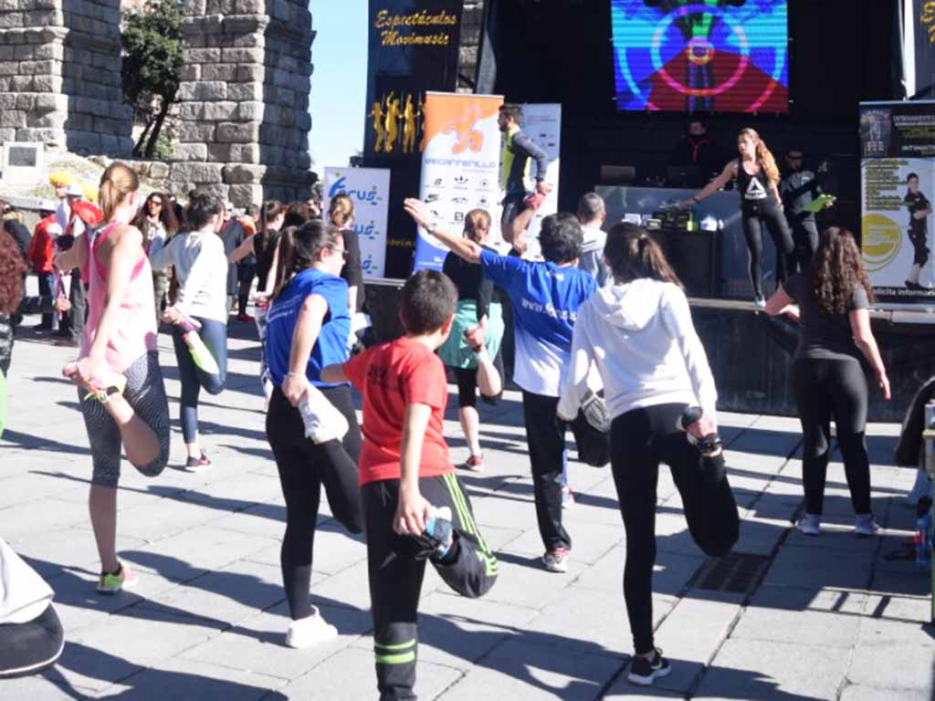 Clase de zumba, en la plaza del Azoguejo en una edición pasada de la carrera monumental de Segovia. / ROCÍO PARDOS