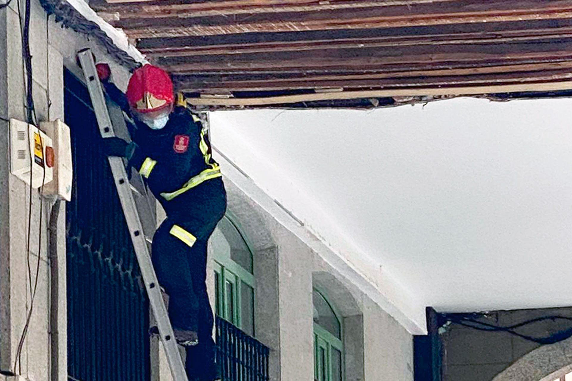 Un bombero procede a inspeccionar la zona y a asegurar el techo del soportal. / E. A.