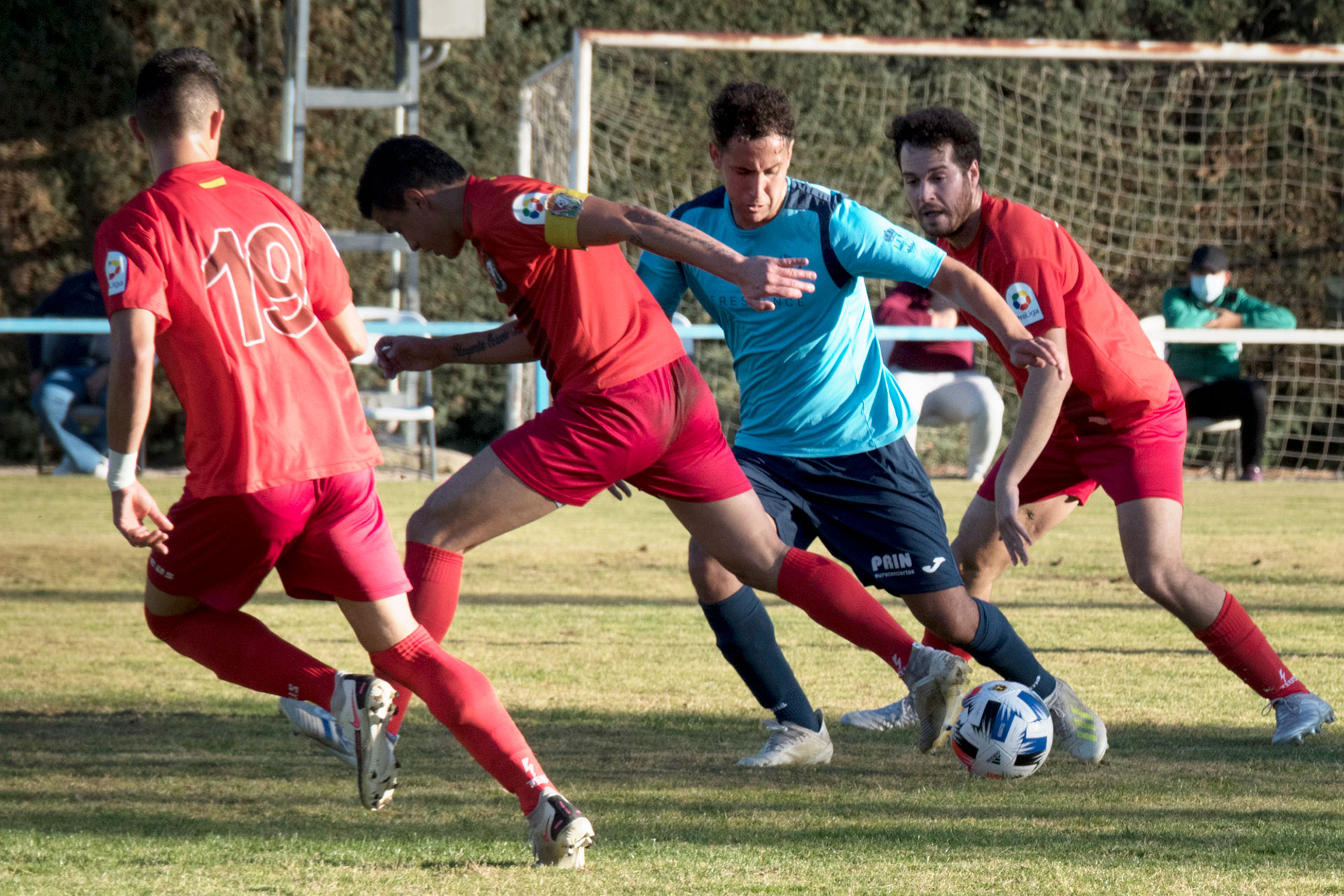 Ibrahim trata de superar la presión de hasta tres contrarios del Real Burgos en un momento del encuentro jugado en el campo de El Hospital./ KAMARERO