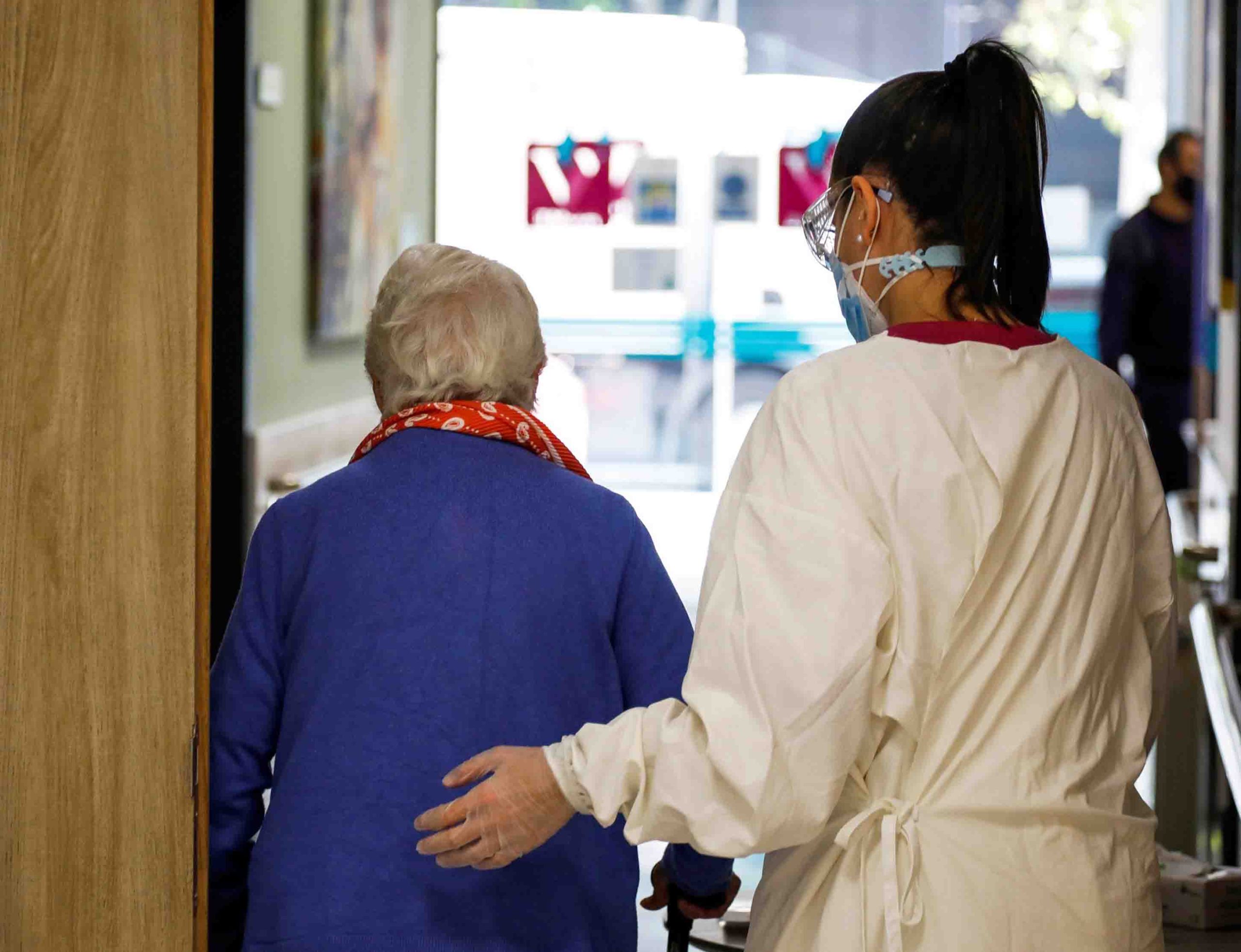 Una trabajadora de ayuda a una paciente. EFE/DAVID FERNÁNDEZ