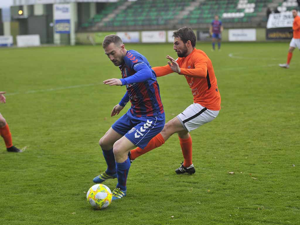 El delantero de la Segoviana Dani Arribas disputa un balón en el centro del campo contra un rival del Burgos Promesas. / KAMARERO