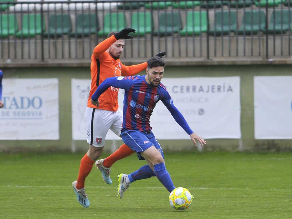 El lateral de la Segoviana Rubén Yubero se va en velocidad de un rival del Burgos Promesas. / KAMARERO