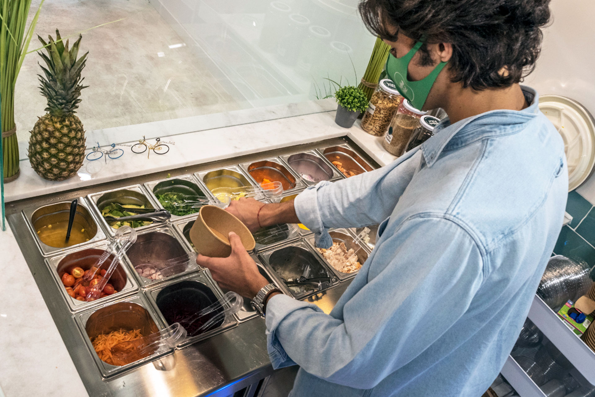 Antonio Ruiz prepara uno de sus pedidos en el restaurante Selfish Poke. / KAMARERO