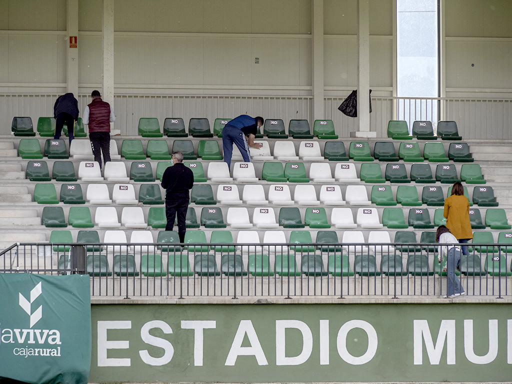 Miembros del club señalizan los asientos disponibles en las gradas de La Albuera. / KAMARERO