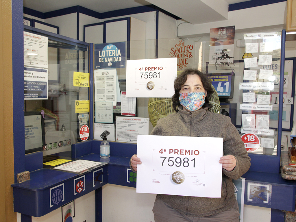 Isabel del Barrio, administradora del punto de venta, muestra el cartel con el número agraciado que vendió en su establecimiento. / NEREA LLORENTE