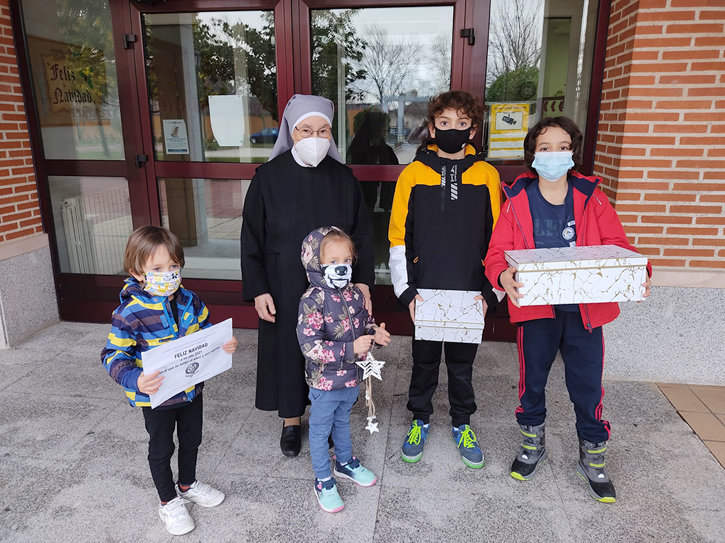 Cuatro escolares entregan las tarjetas en las Hermanitas de los Pobres. / E. A.