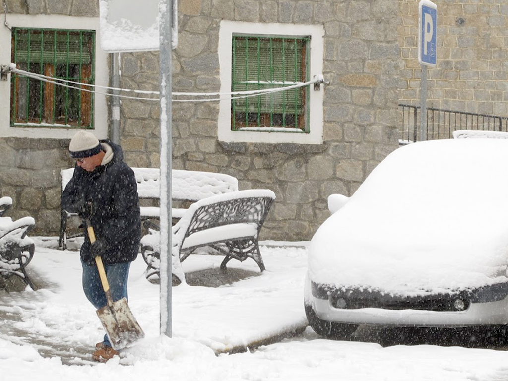 Un vecino limpia una acera en el barrio de San José tras la nevada de enero de 2018. / E. A.