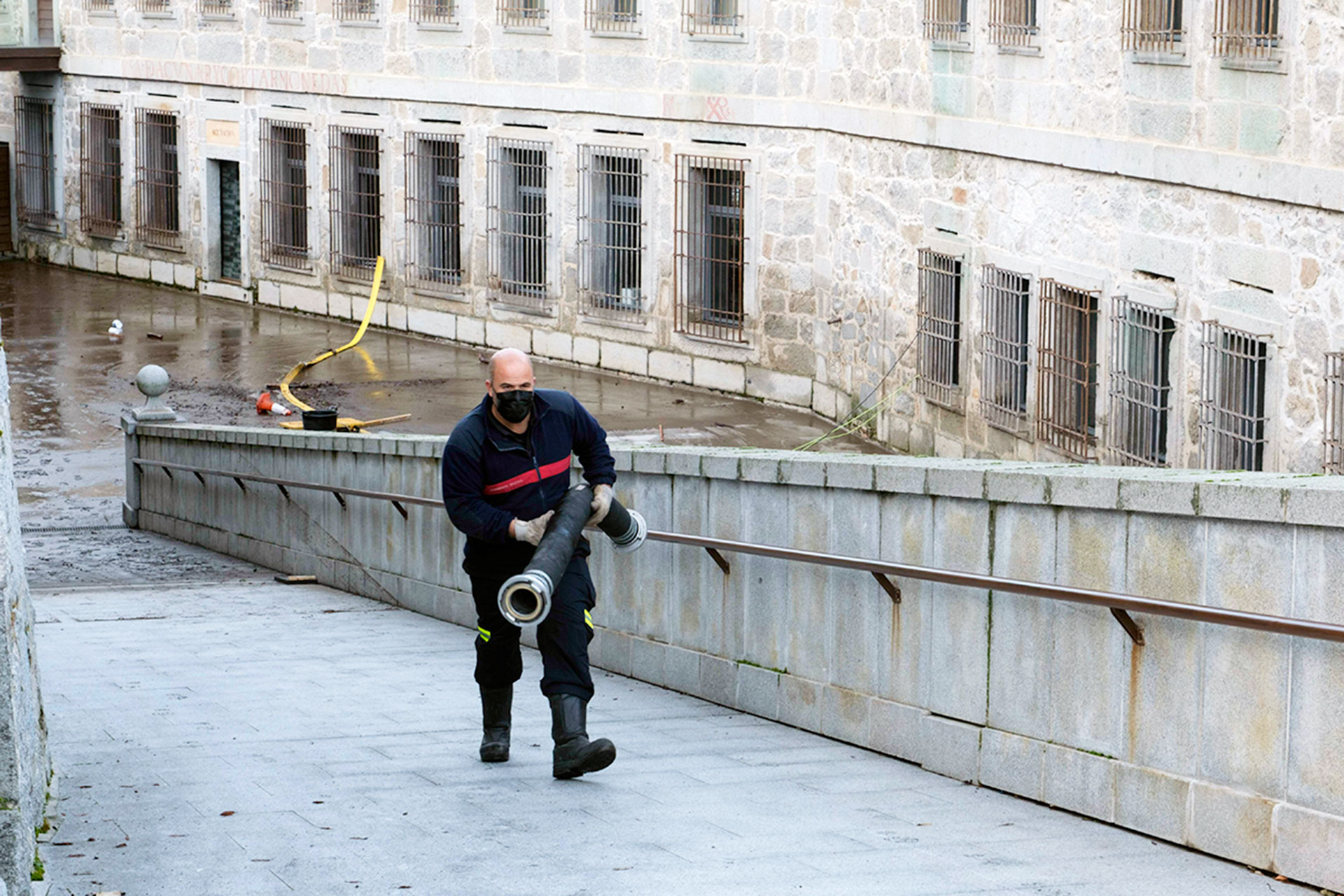 Uno de los bomberos traslada una de las mangueras utilizadas en la Casa de la Moneda. / KAMARERO