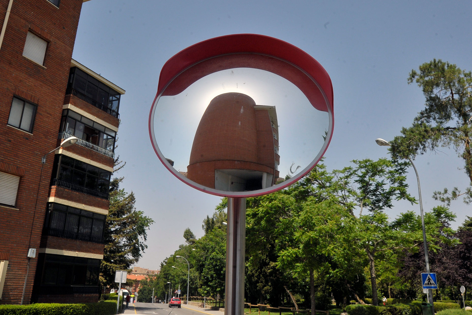 El edificio de viviendas de Evisego reflejado en un espejo de tráfico. / Kamarero