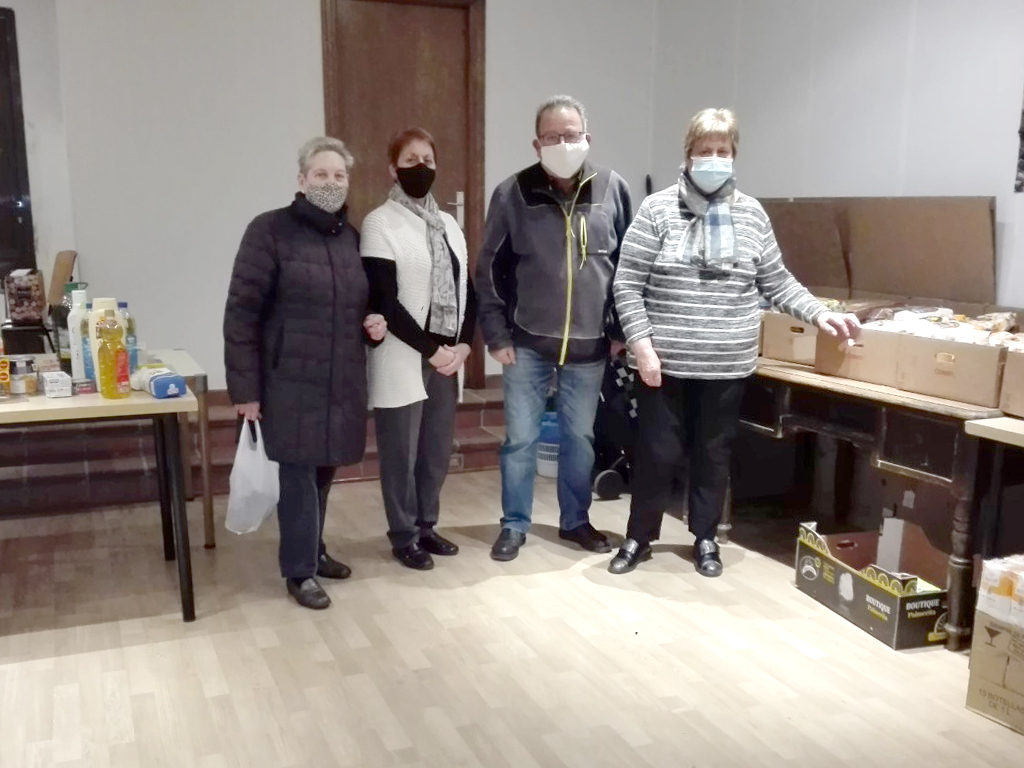 Los integrantes de Cáritas parroquial posan junto a los alimentos donados por los vecinos. / L.M.