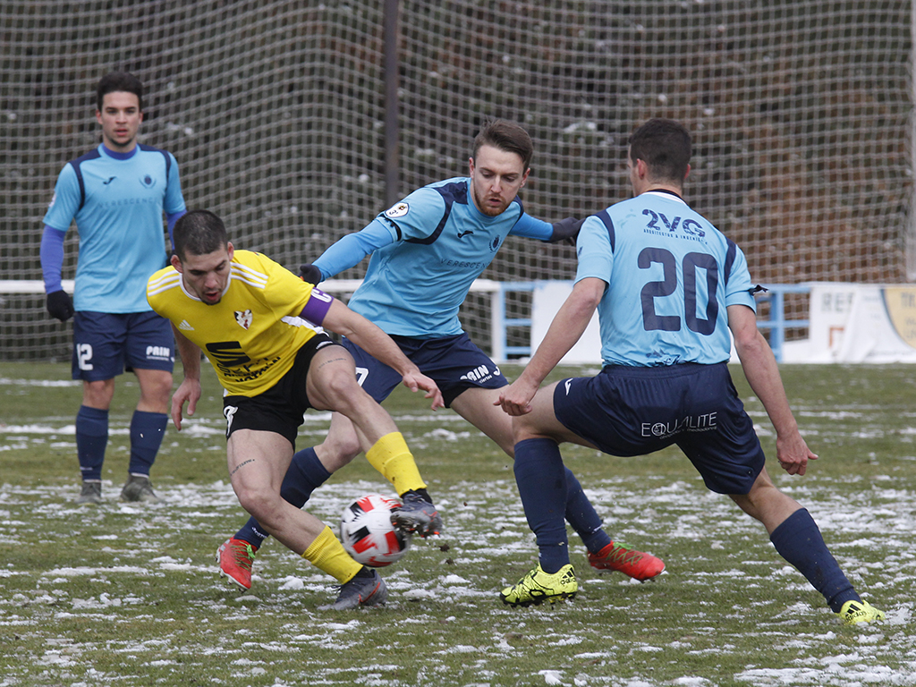 Miguel y Gabi tratan de presionar la acción ofensiva del jugador del Bupolsa durante la primera parte del encuentro disputado en el campo de El Hospital./ NEREA LLORENTE