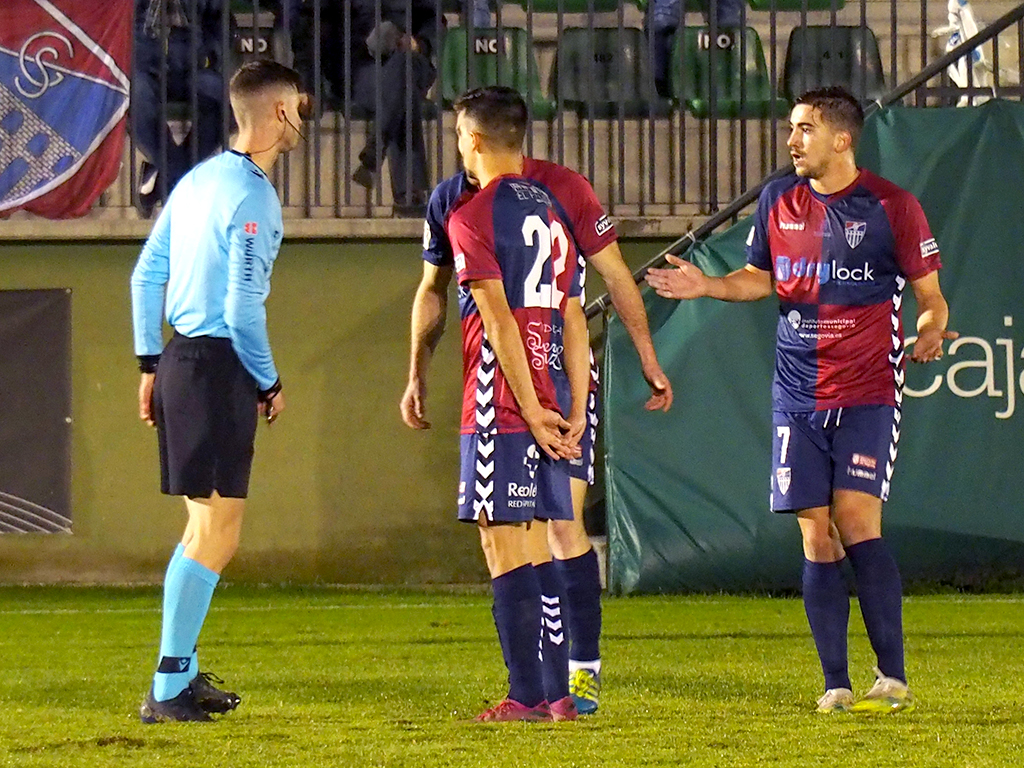 Los jugadores de la Segoviana lamentan ante el colegiado la expulsión de Dani Arribas ante el Girona. / KAMARERO