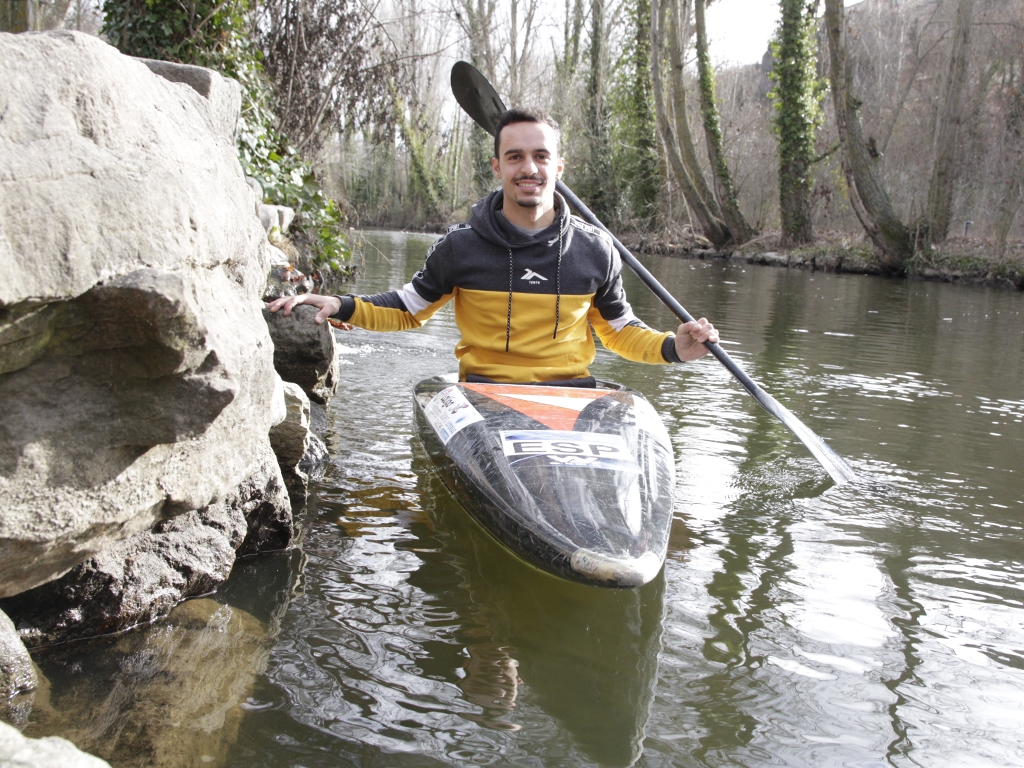 Darío Cuesta posa con su piragua en la ribera del Eresma. / NEREA LLORENTE