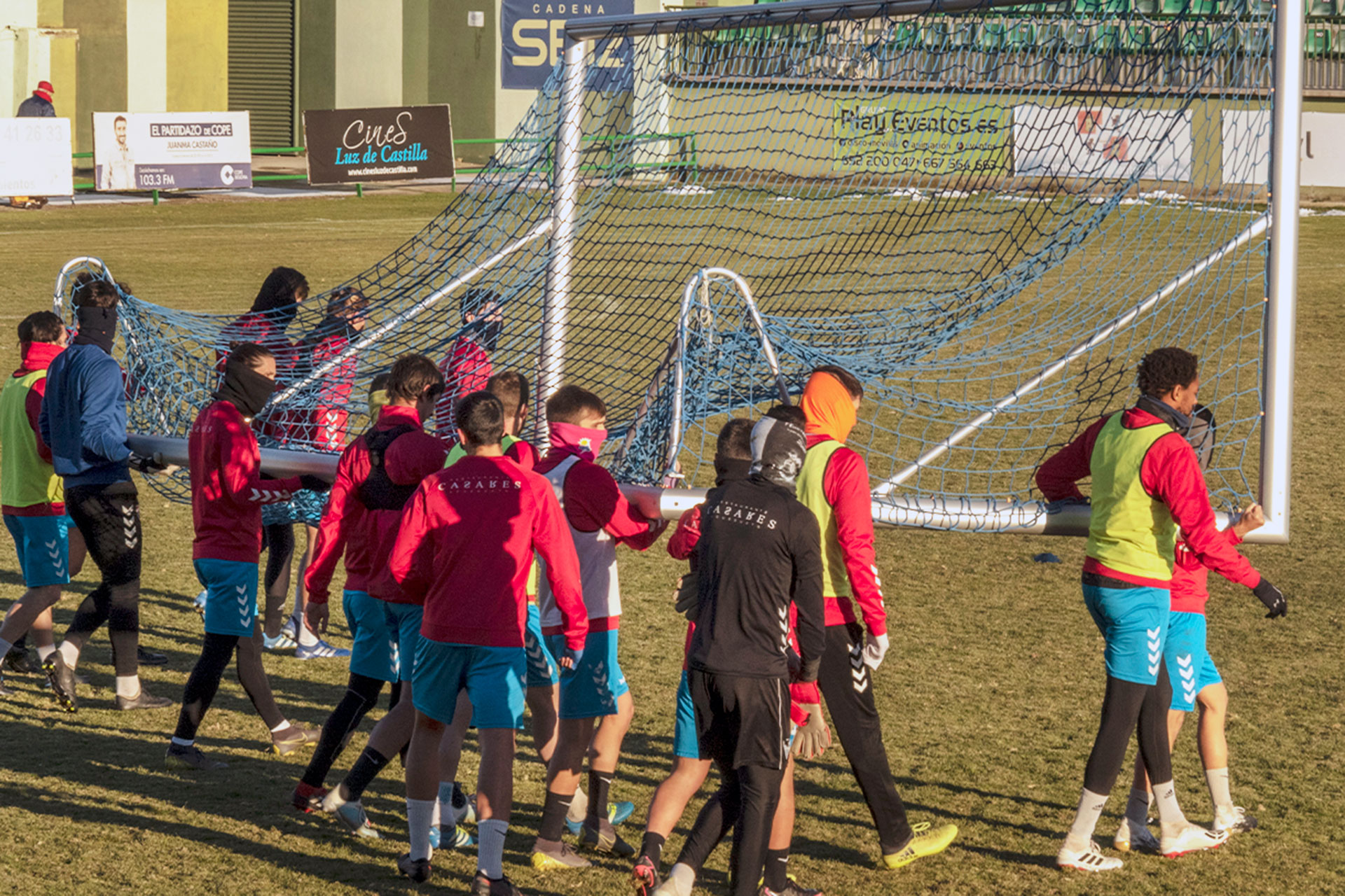 Los jugadores de la Segoviana trasladan una de las porterías para llevar a cabo un ejercicio./ KAMARERO