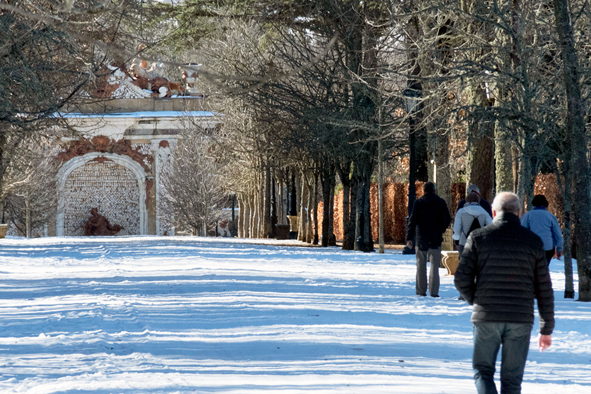 Los primeros visitantes ayer al Palacio Real de La Granja, después de unos días cerrado, disfrutaron caminando sobre la nieve. /KAMARERO