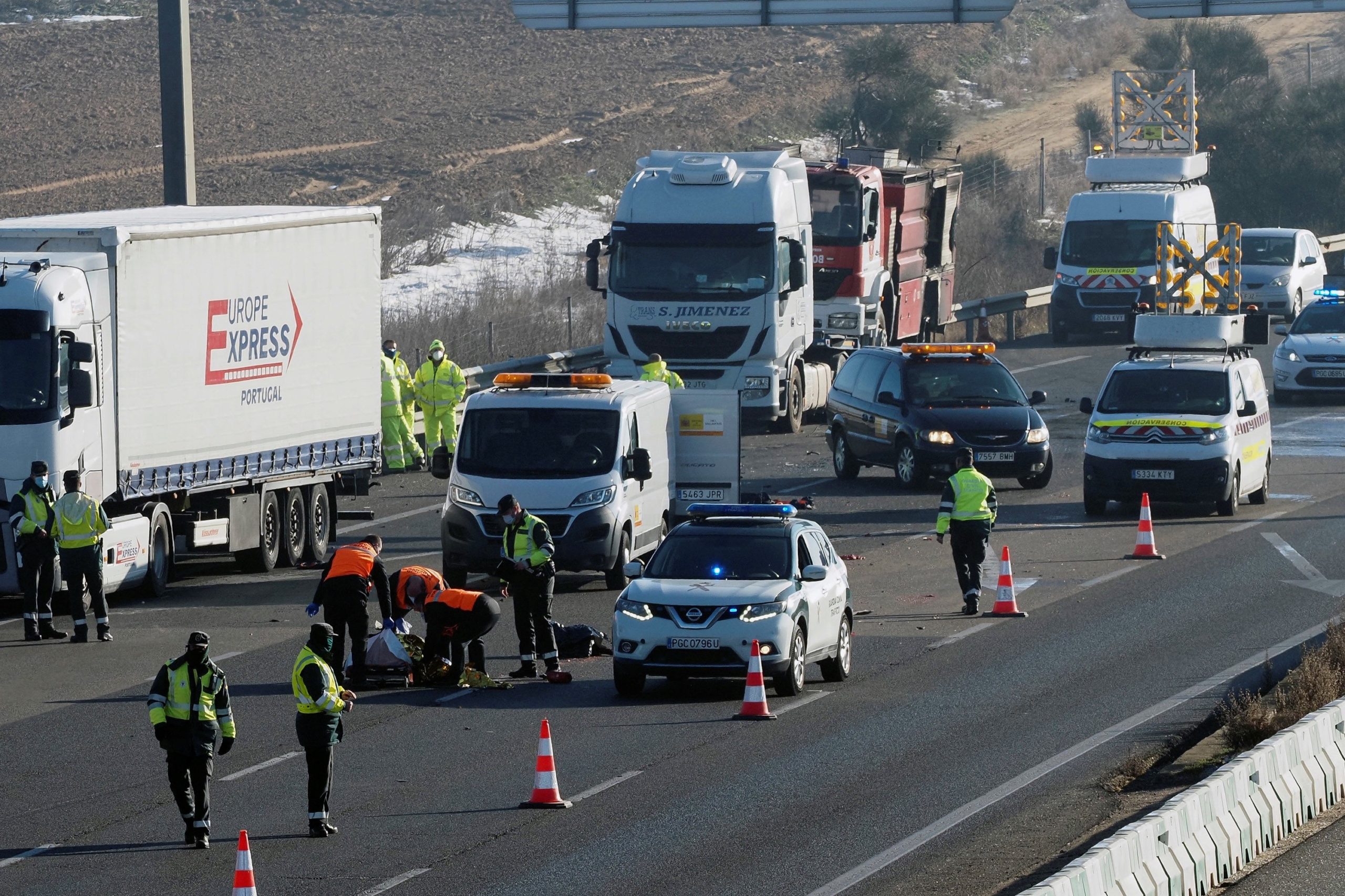 Agentes de la Guardia Civil junto al cuerpo sin vida de uno de los conductores de tres camiones que han fallecido en la A-6, en Tordesillas (Valladolid), tras ser atropellados por un cuarto camión, cuando intentaban apagar el incendio que se había producido en uno de los articulados. EFE/ R. García
