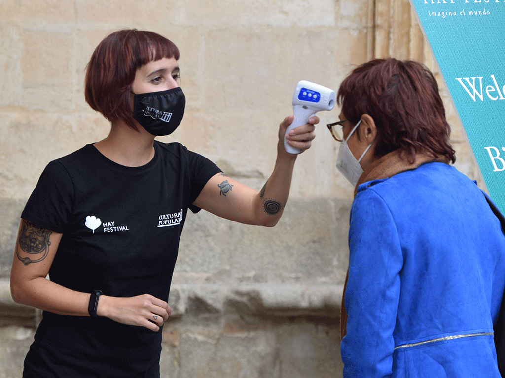 Una empleada toma la temperatura a una persona a la entrada de un evento cultural. / ROCÍO PARDOS