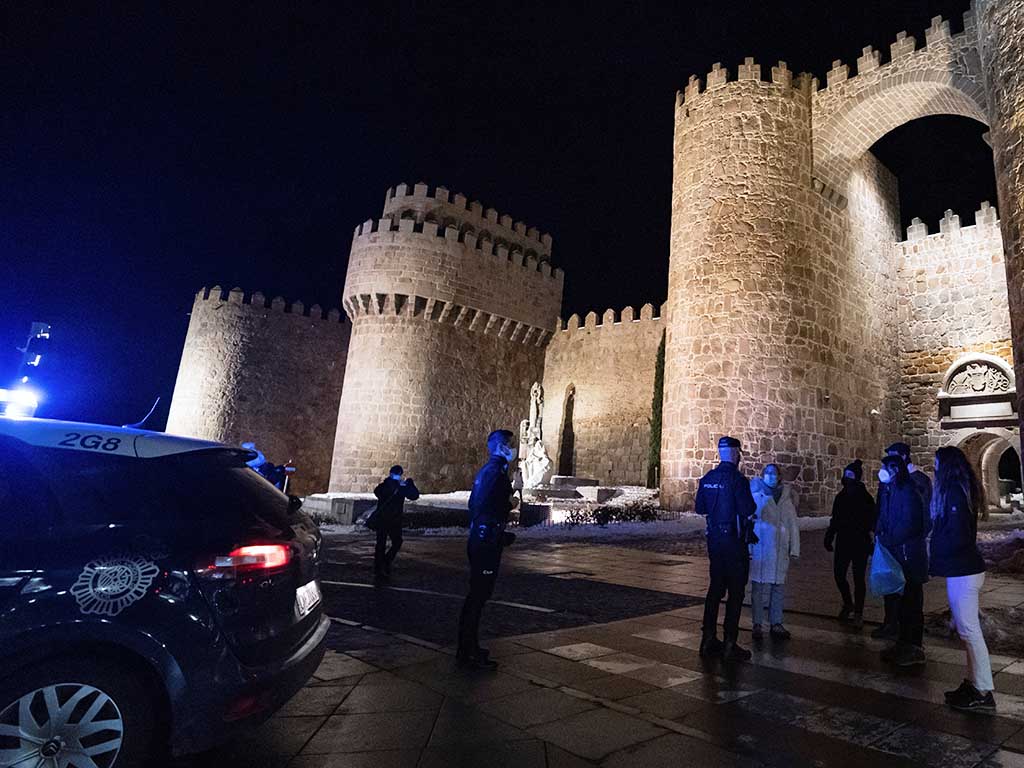 Agentes de la Policía Nacional conversan con un grupo de jóvenes durante el primer día con toque de queda a las 20:00 en Ávila. EFE/ Raúl Sanchidrián