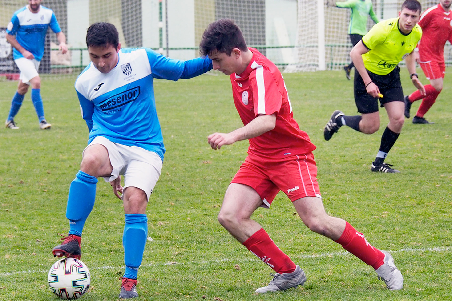 Quino pisa el balón ante la oposición de un contrario y la atenta mirada del colegiado./ KAMARERO