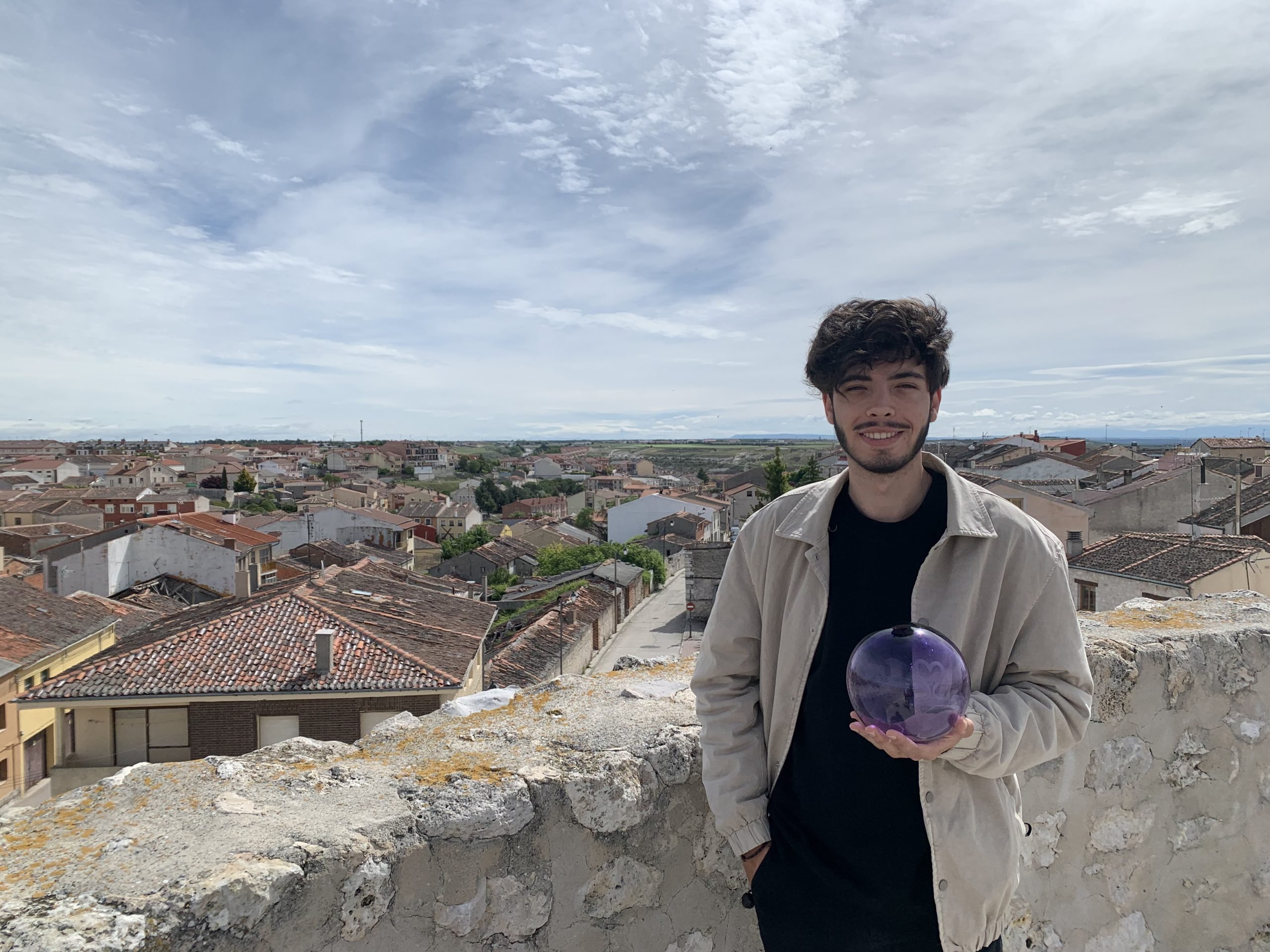 Cristian Cerezo sostiene su premio sobre la muralla y con Cuéllar de fondo.